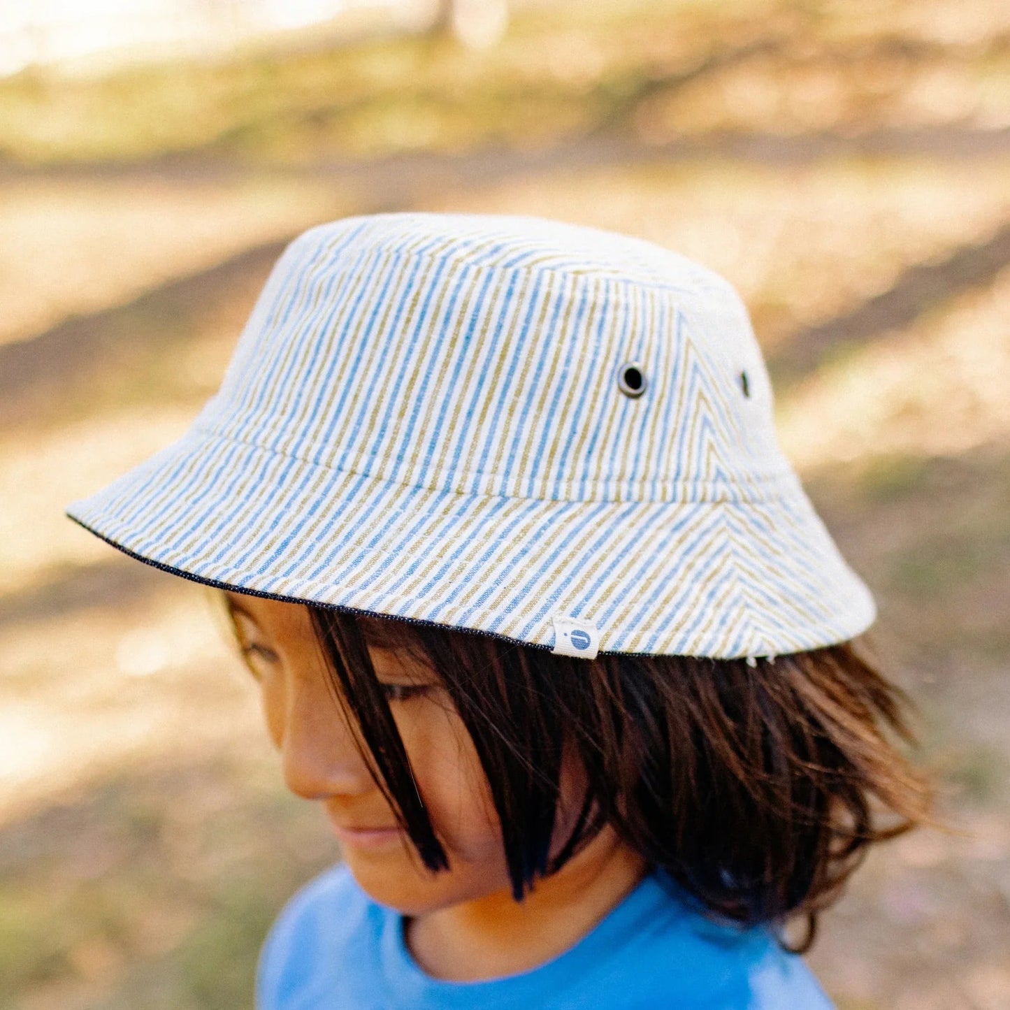 Child wearing a striped bucket hat outdoors