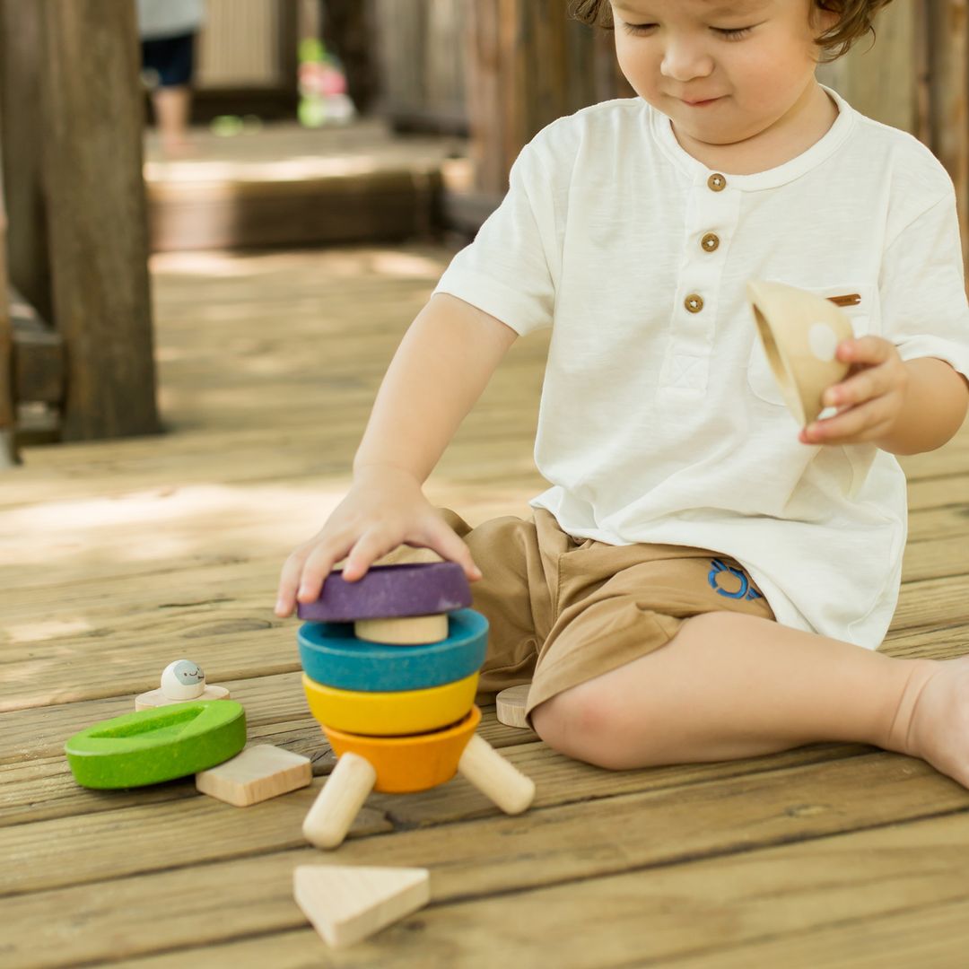 Child playing with wooden toys on a wooden deck