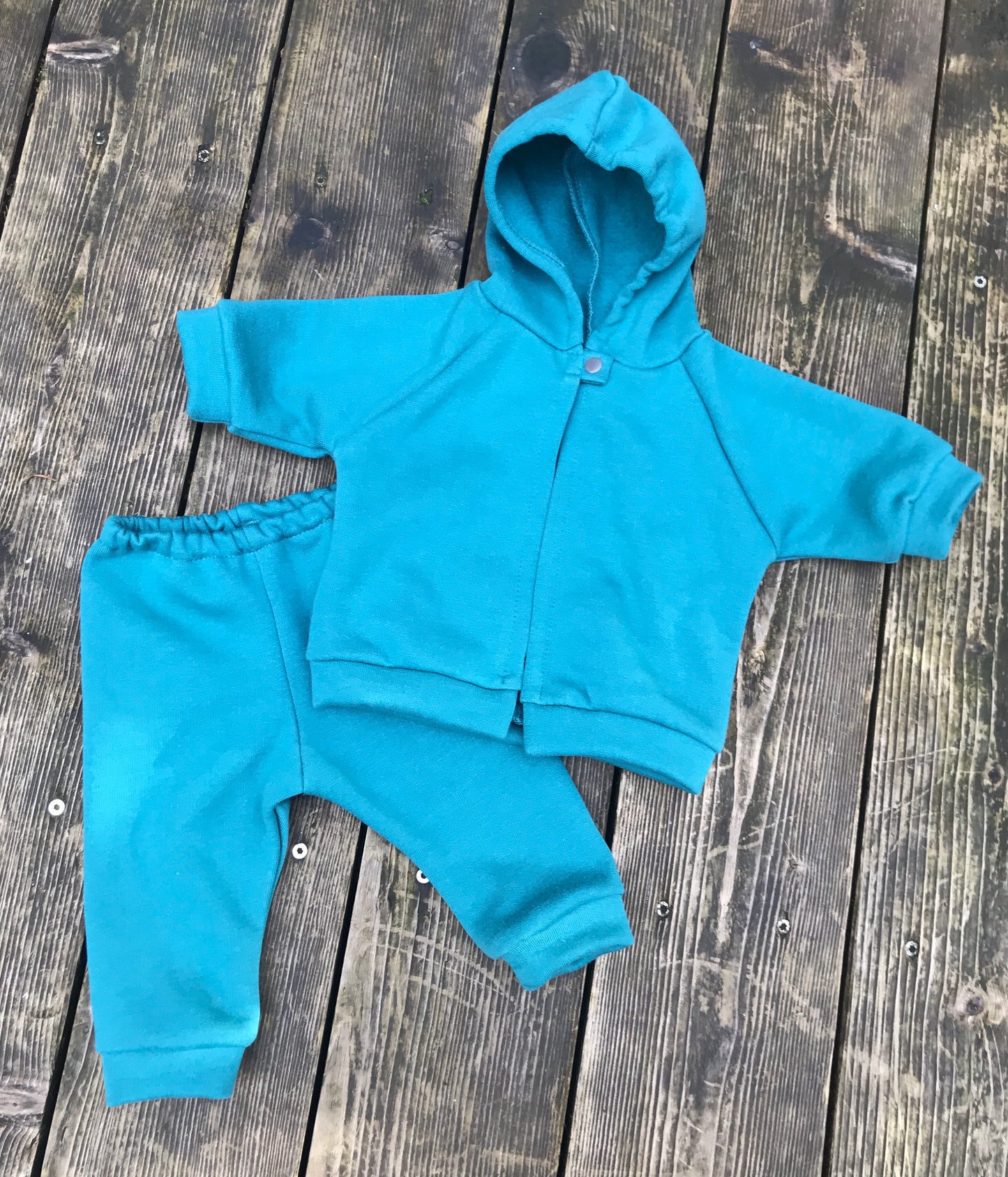 Tea; children's hoodie and pants set on a wooden surface