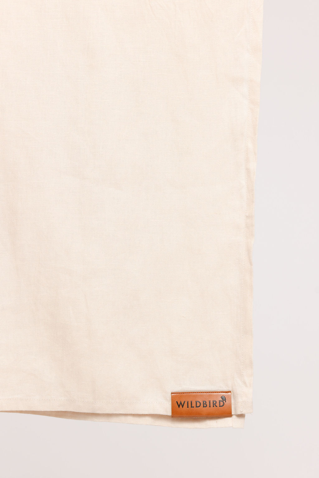 Beige fabric with a brown leather label on a white background