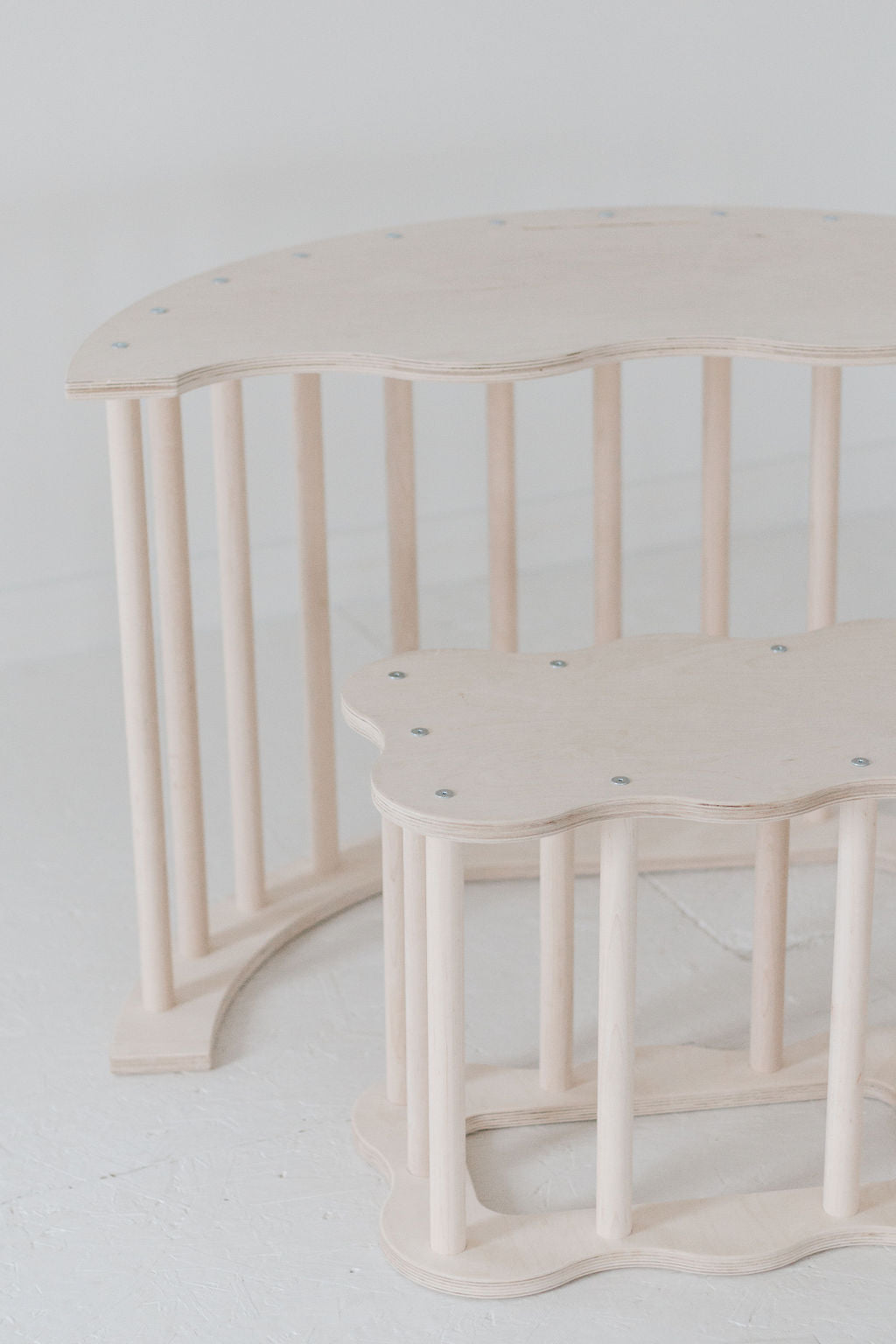 Two light wood benches against a white background