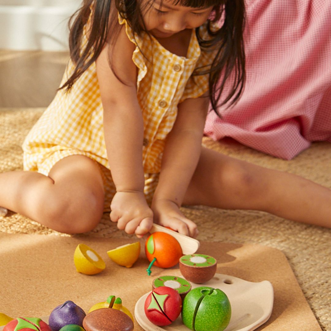 Child playing with colorful wooden toys on a wooden surface