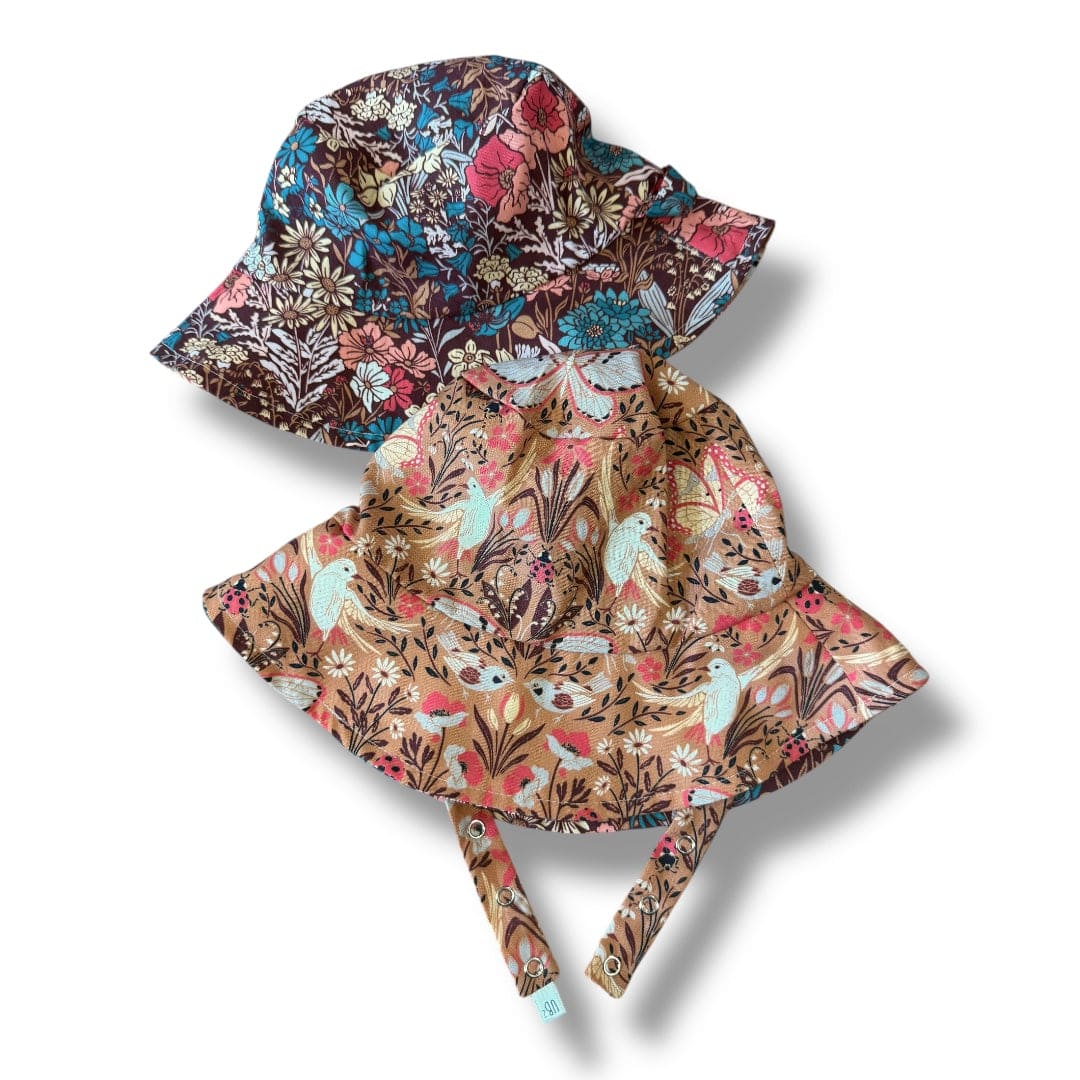 Two floral-patterned sun hats on a white background