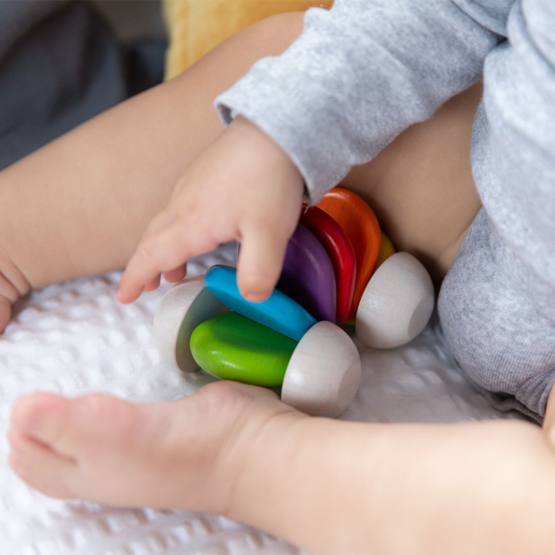 Child playing with colorful stacking toys on a soft surface