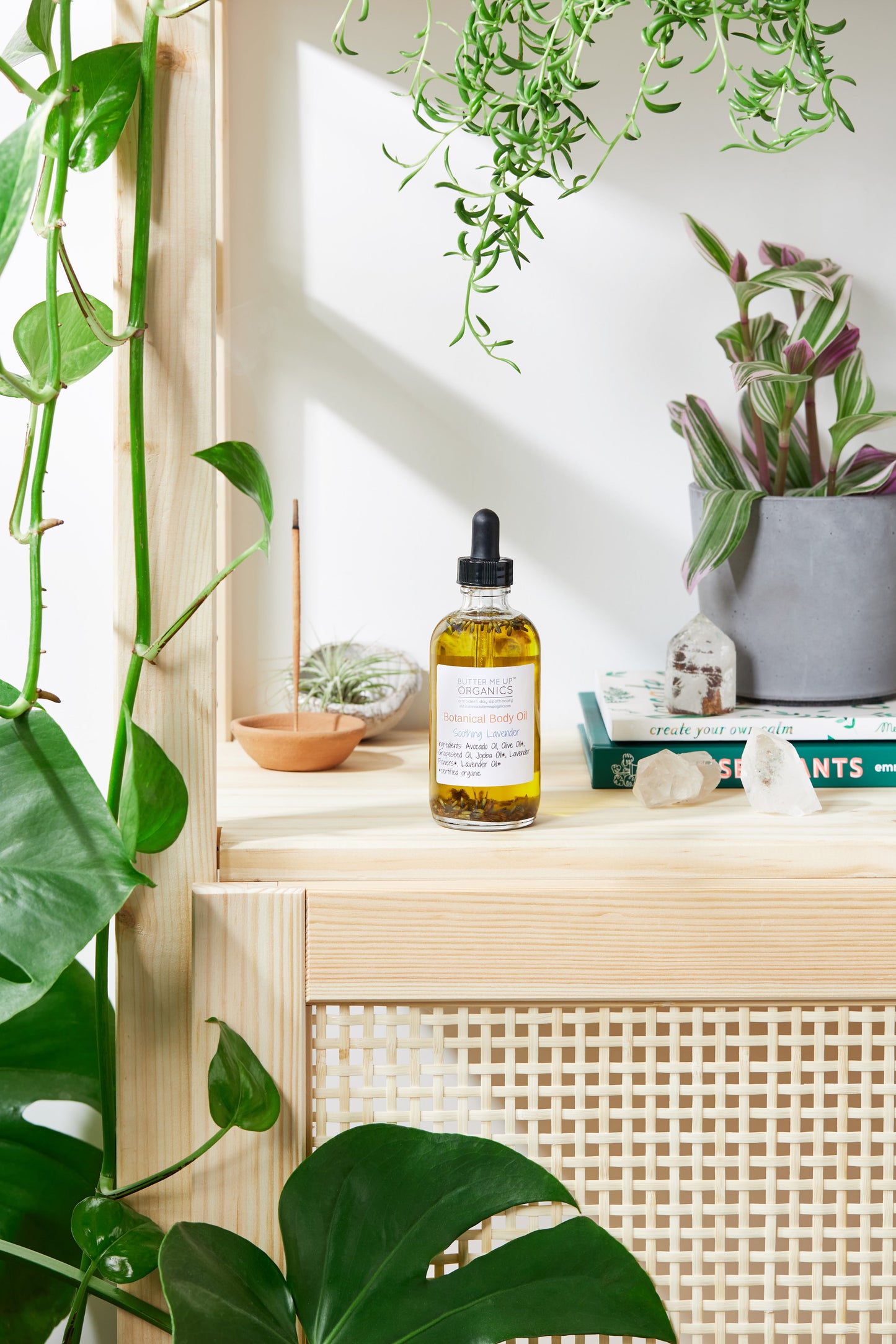Bottle of oil on a wooden shelf with plants in the background