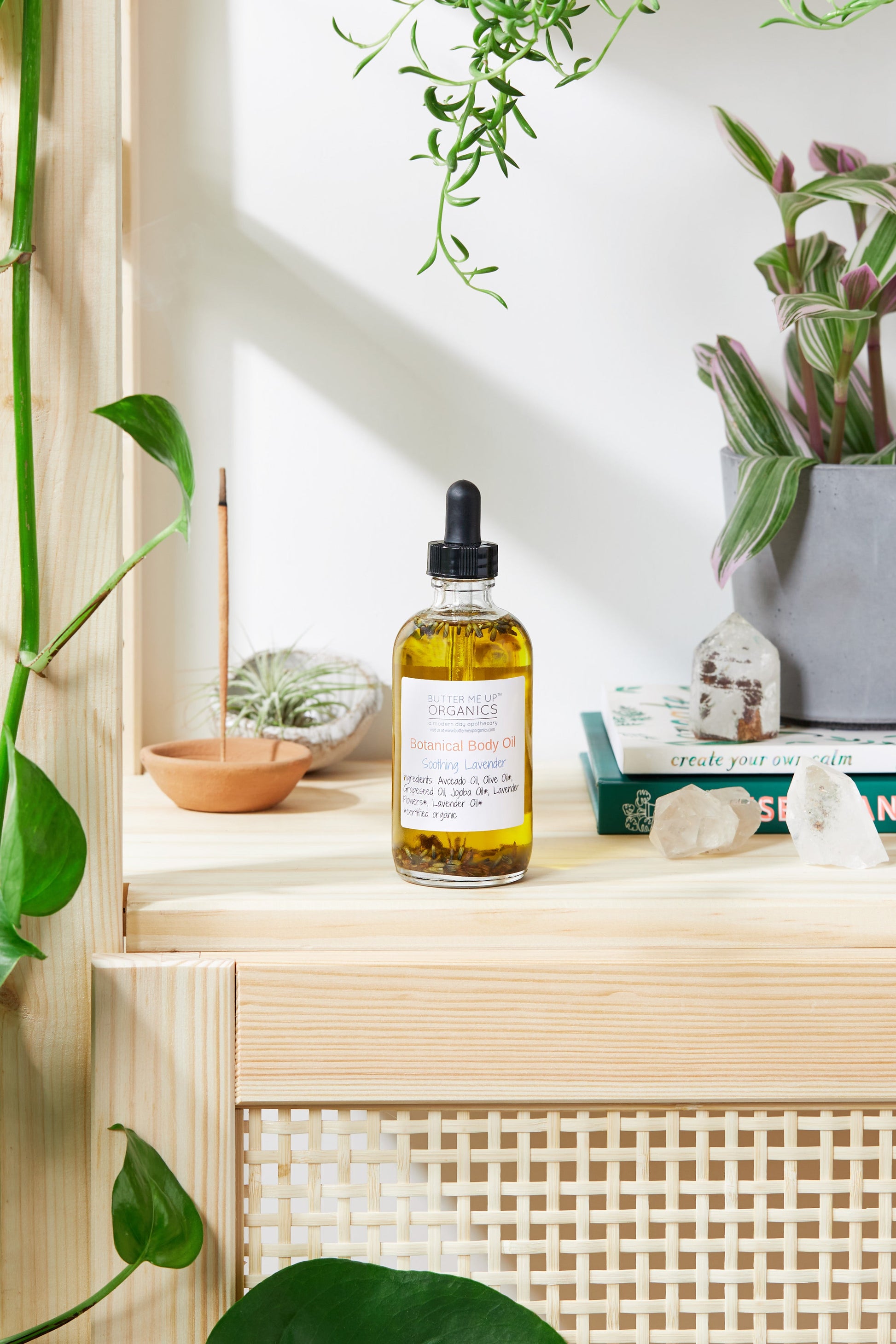 Bottle of oil on a wooden shelf with plants and decor items