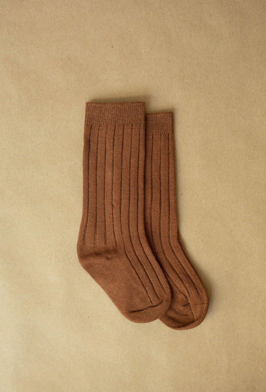 Pair of brown socks on a beige background