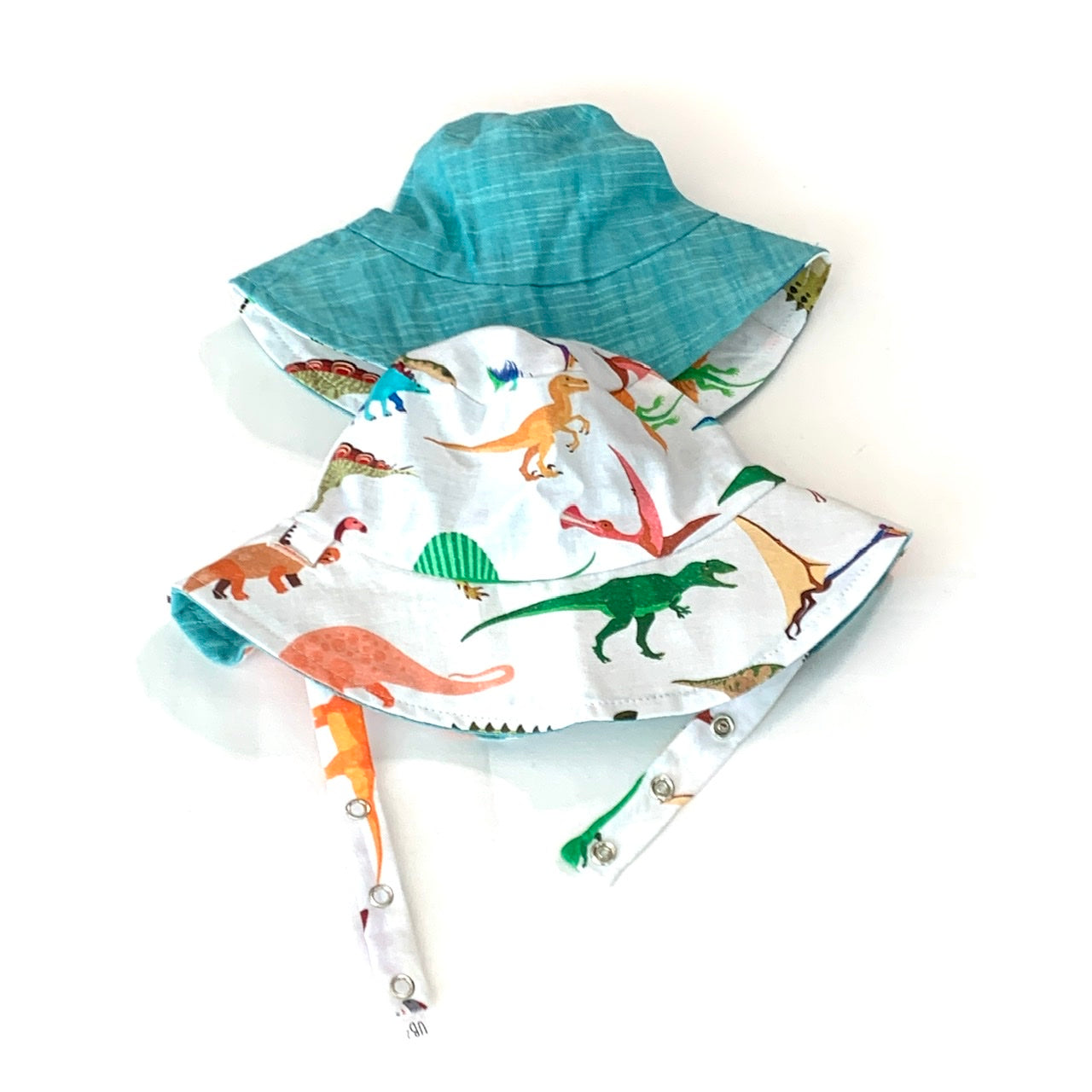 Children's dinosaur-themed sun hat and bib on a white background