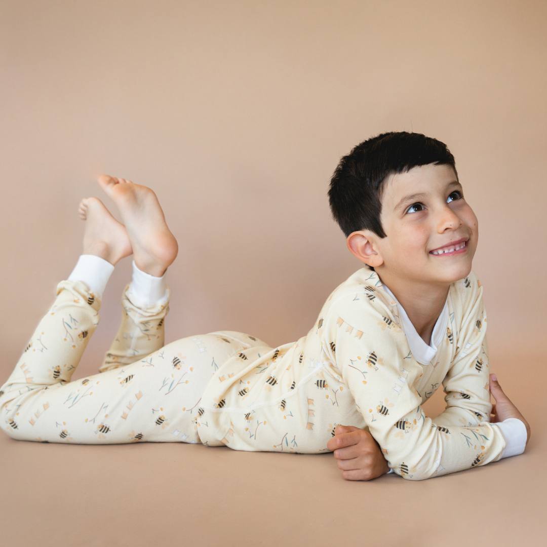 Child wearing a patterned onesie on a beige background