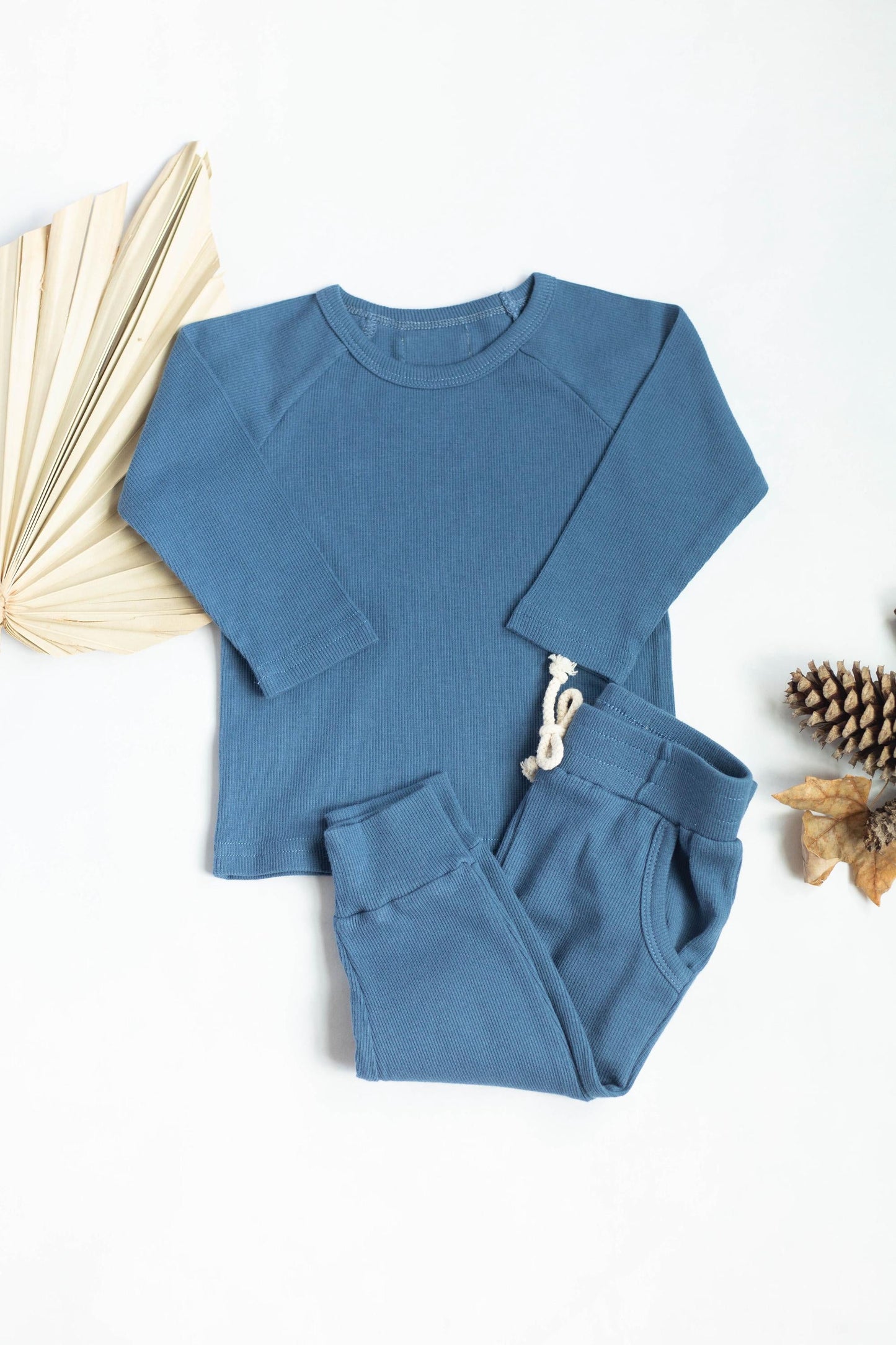 Blue children's outfit with long-sleeve top and pants on a white background