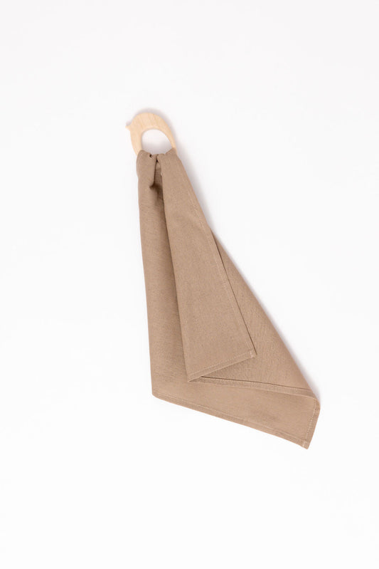 Beige napkin folded into a triangle shape on a white background