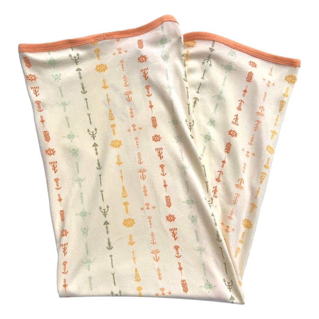 Two folded fabric swaddles with a floral pattern on a white background