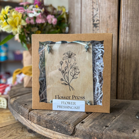 Flower pressing kit with dried flowers on a wooden surface