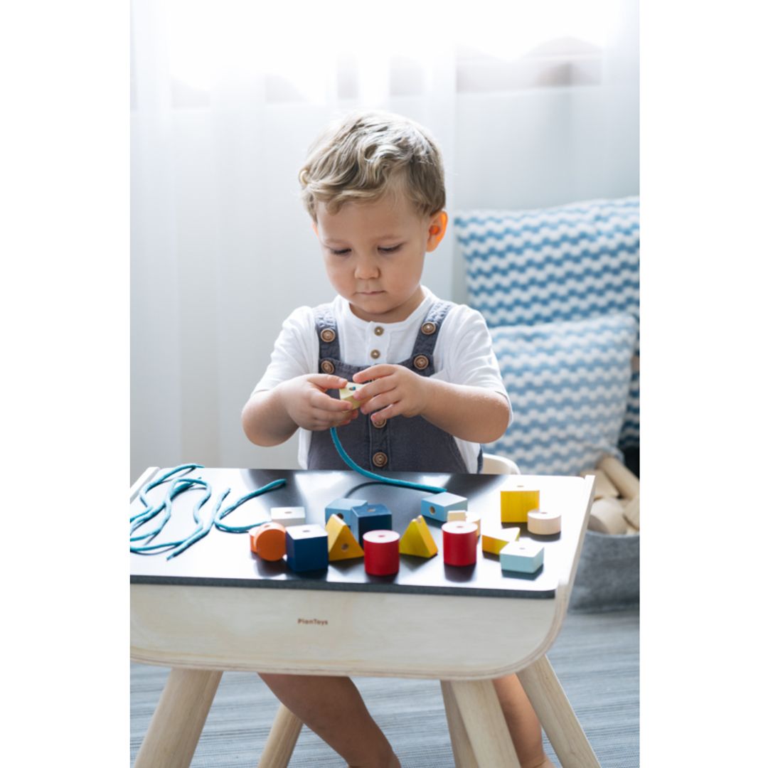 Child playing with colorful blocks on a table in a home setting