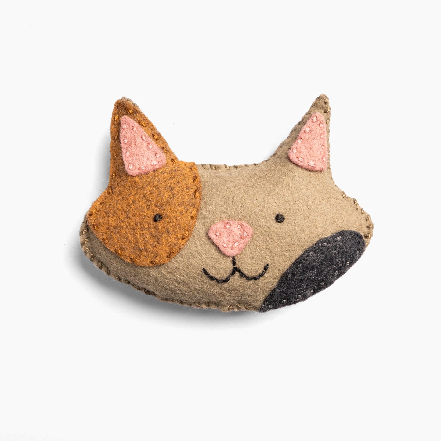 Stuffed animal head of a cat with brown face and pink ears on a white background