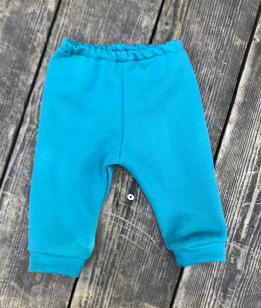 teal baby pants on a wooden surface