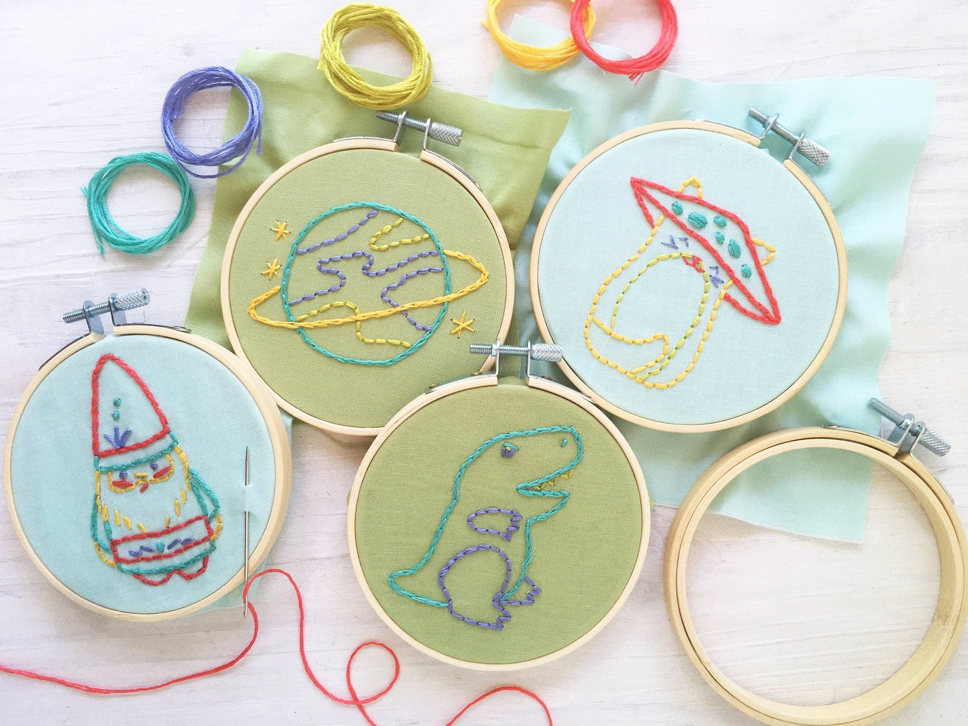 Embroidery hoops with space-themed designs on a light background