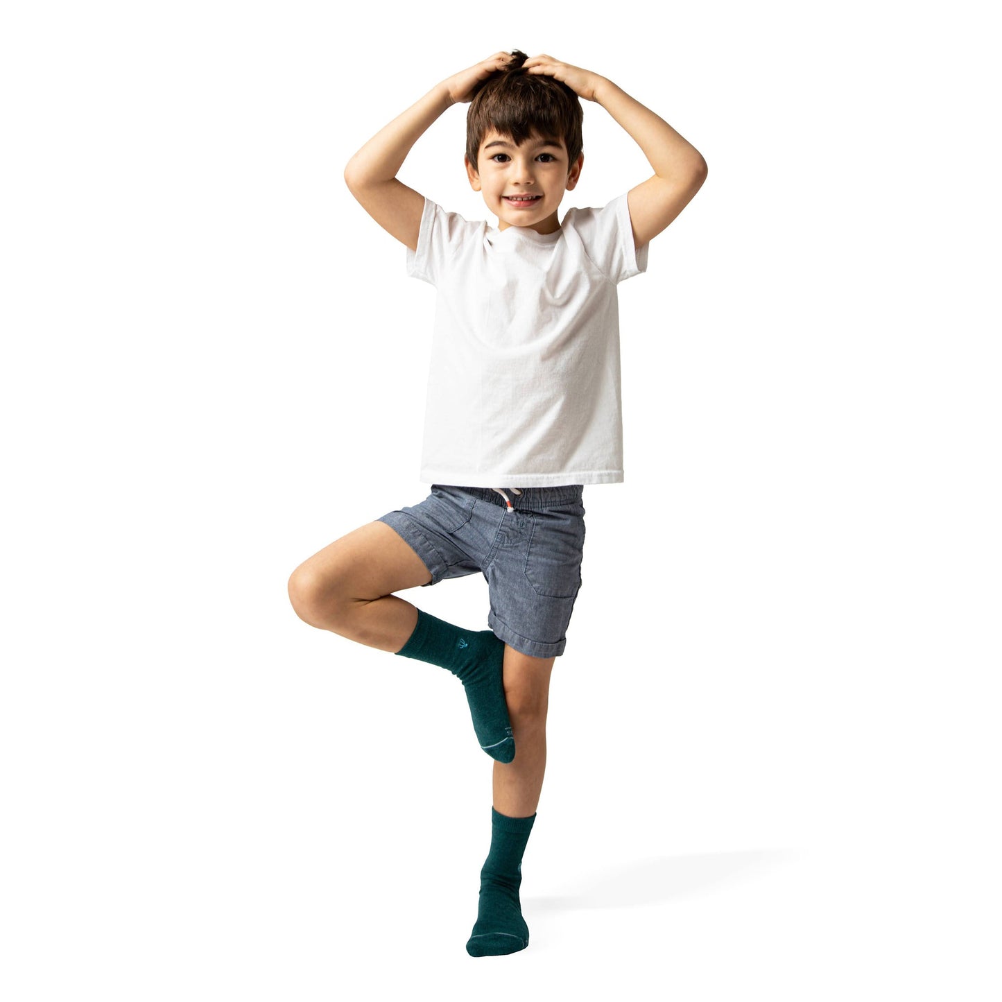 Child wearing a white t-shirt, gray shorts, and green socks on a white background