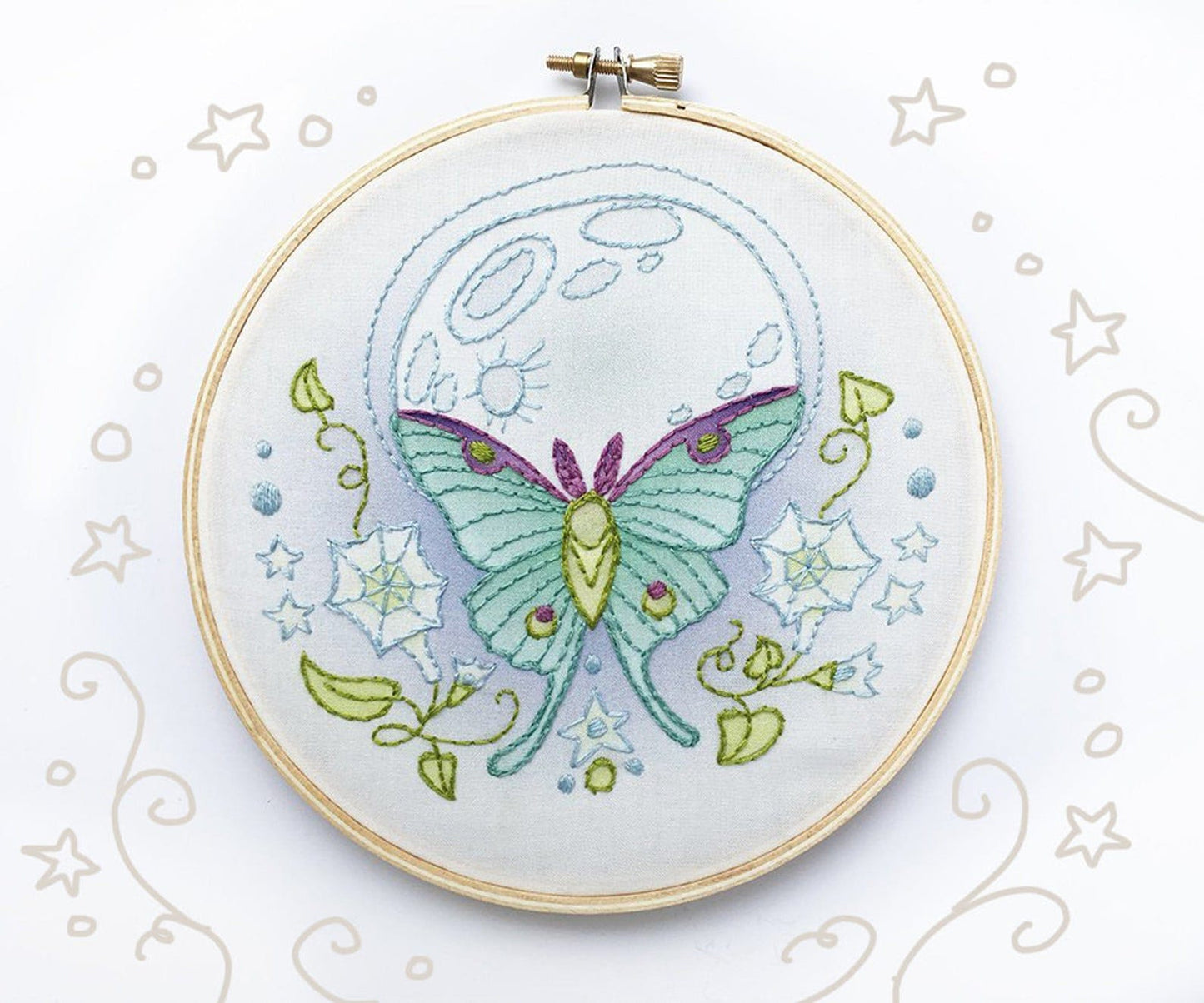 Embroidery hoop with a green butterfly design on a white background