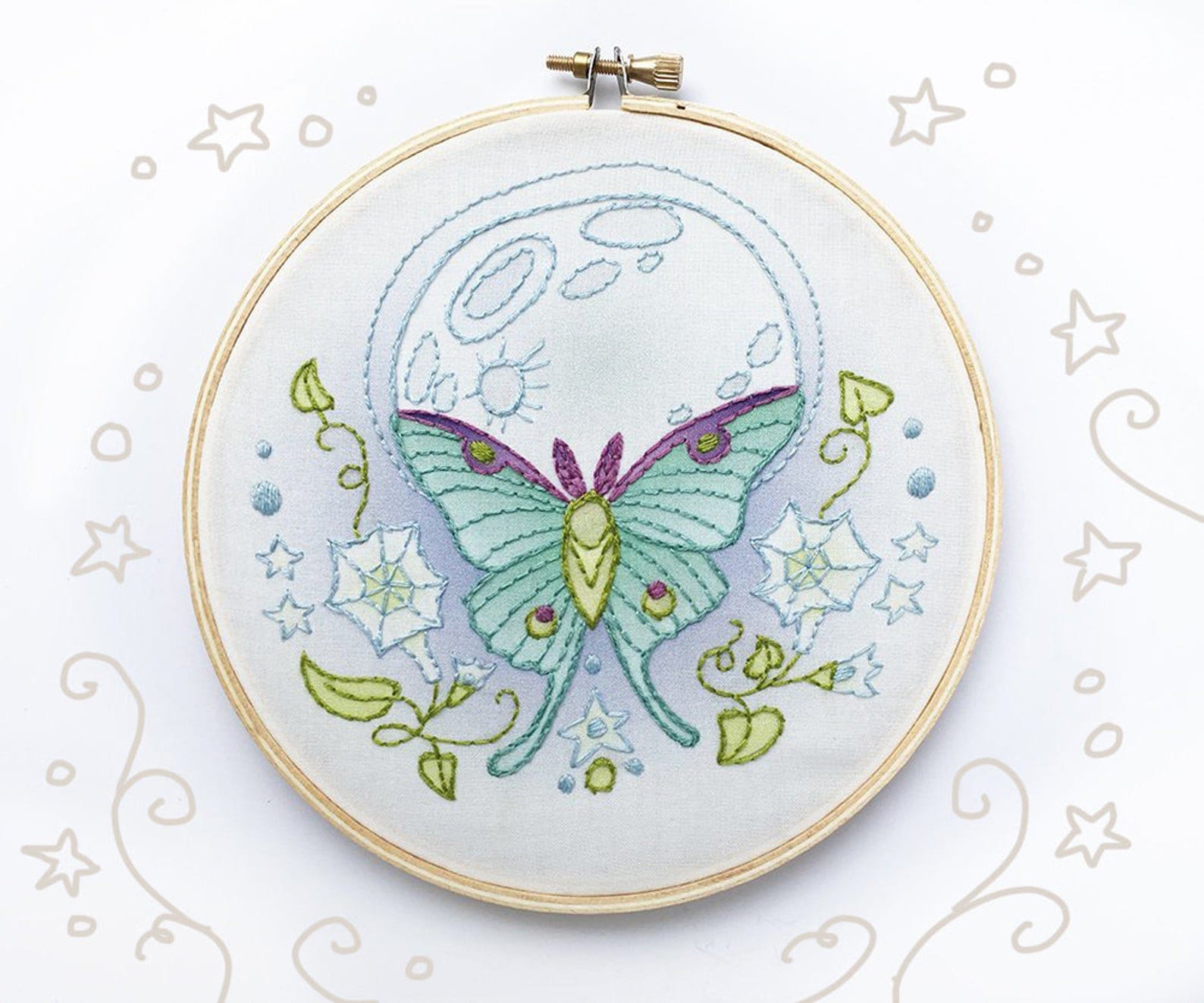 Embroidery hoop with a green butterfly design on a white background