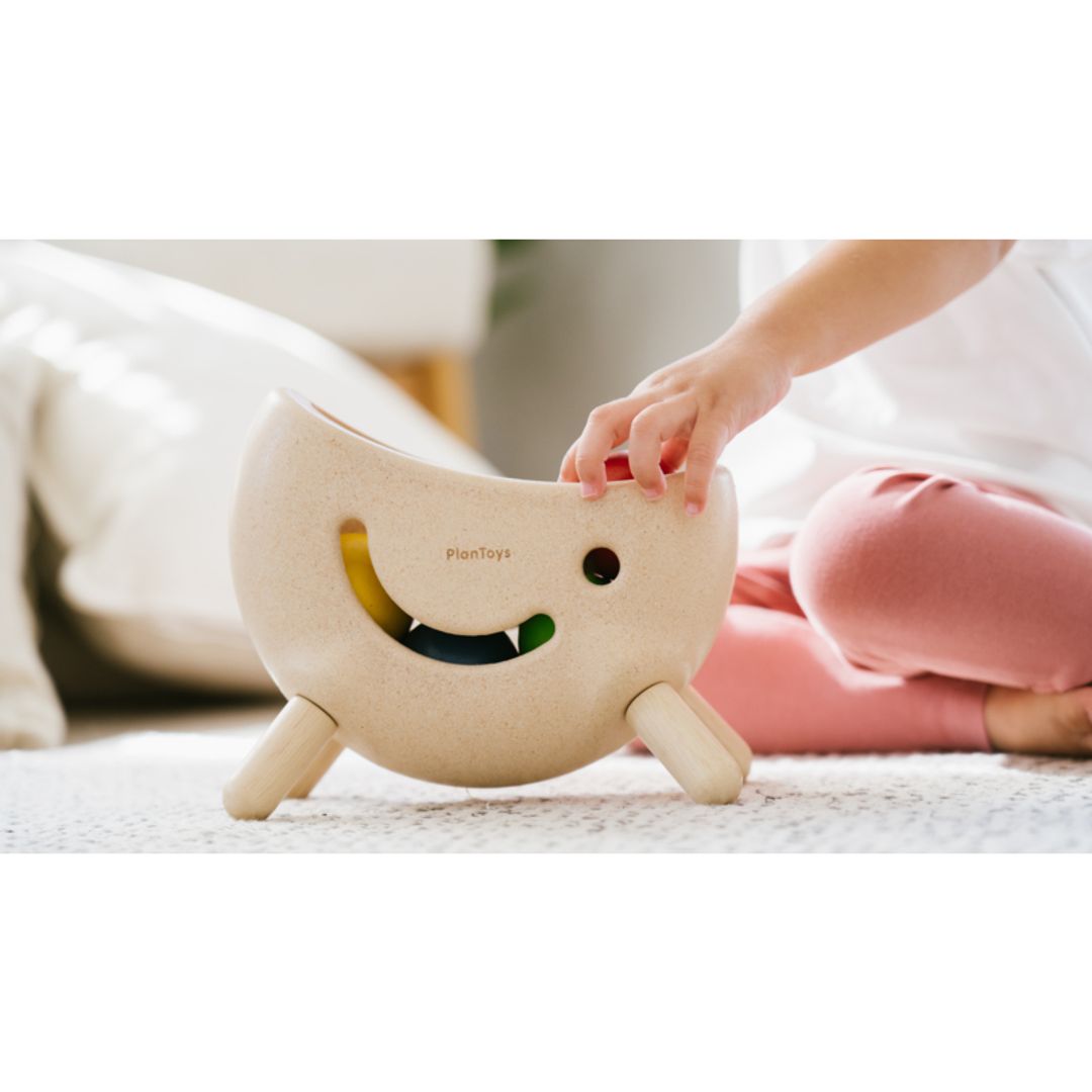 Child playing with a plush toy on a bed