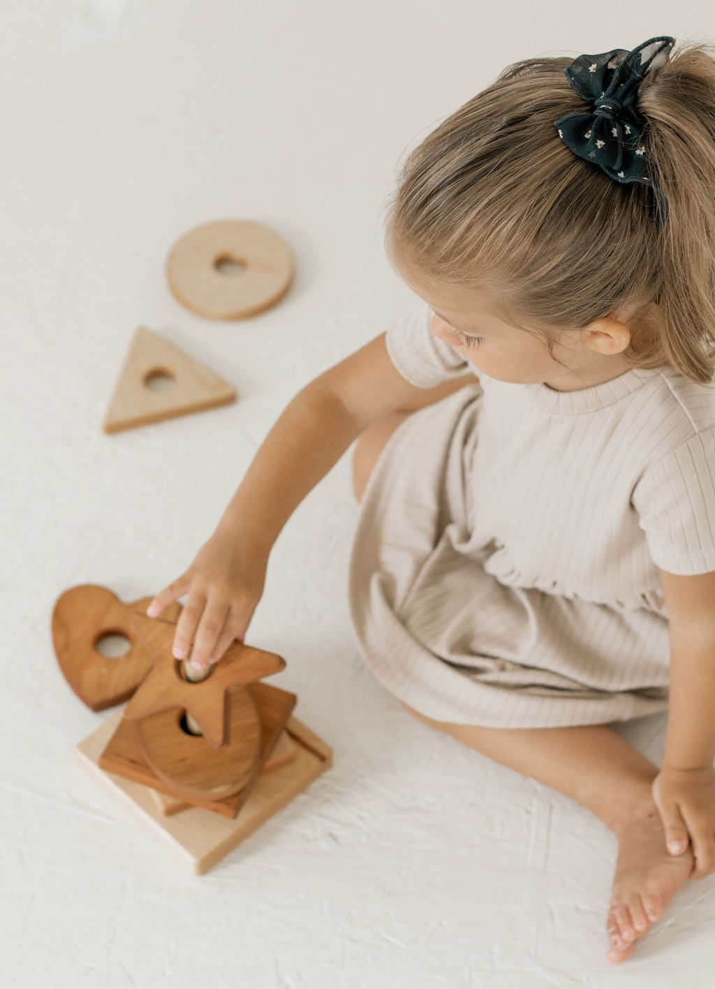Child playing with wooden toys on a light surface
