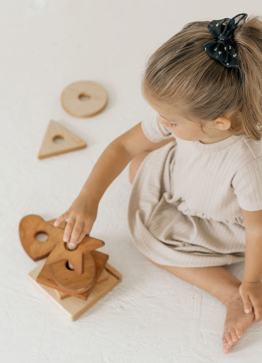 Child playing with wooden toys on a light surface