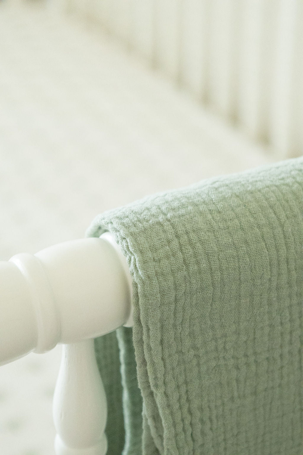 Close-up of a green textured blanket on a white surface
