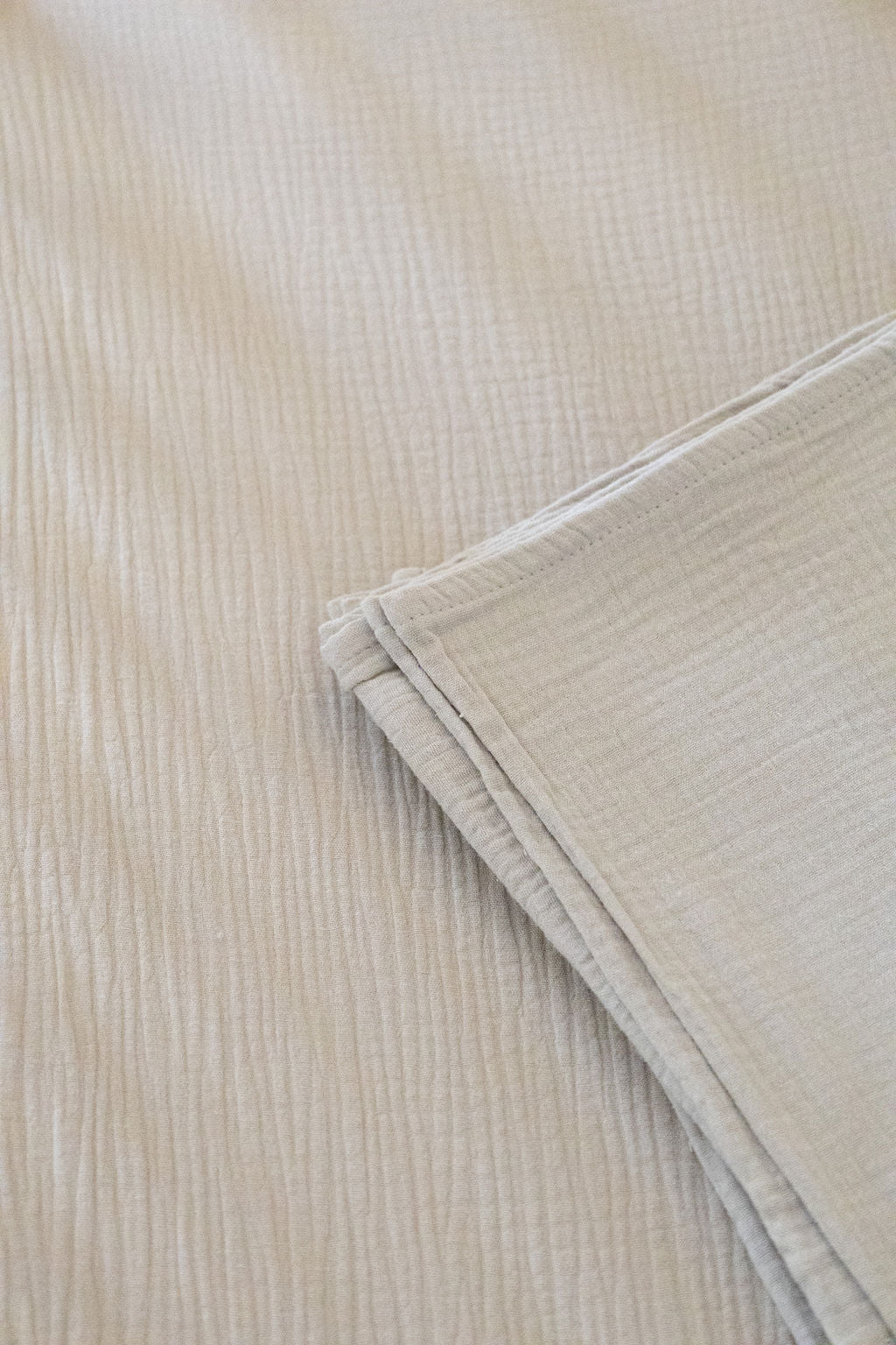 Close-up of beige textured fabric with a folded edge