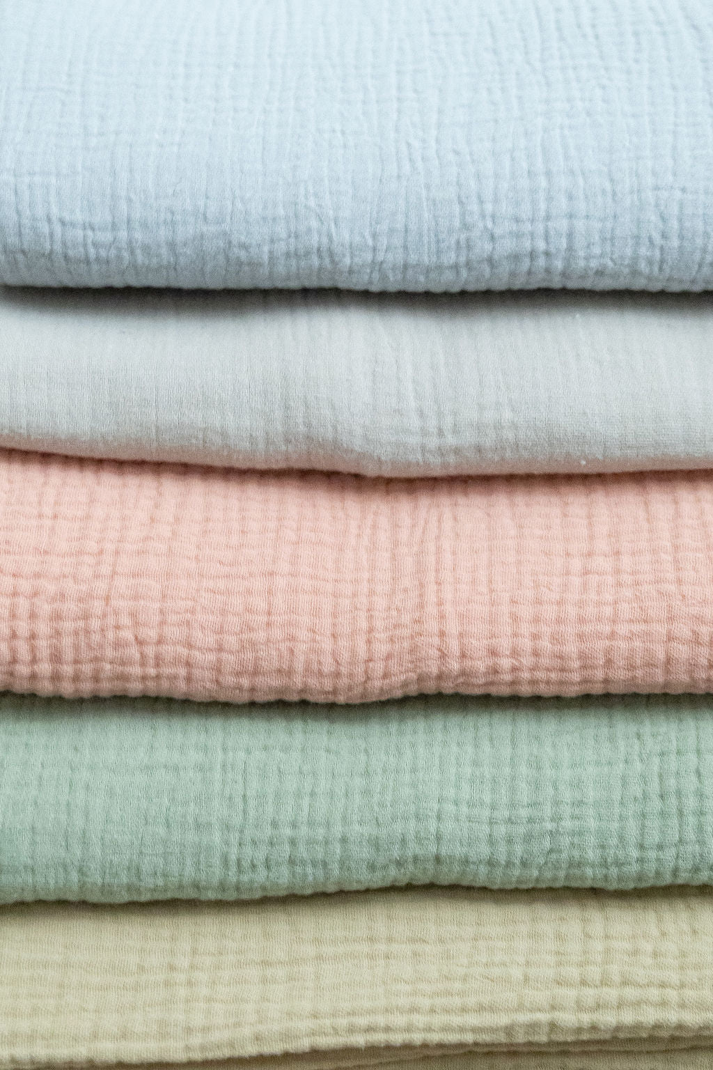 Stack of folded fabric swatches in pastel colors
