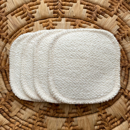 Set of white woven pads on a wicker surface