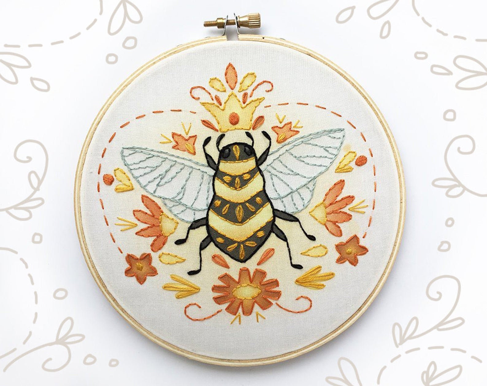 Embroidery hoop with a bee design on a white background
