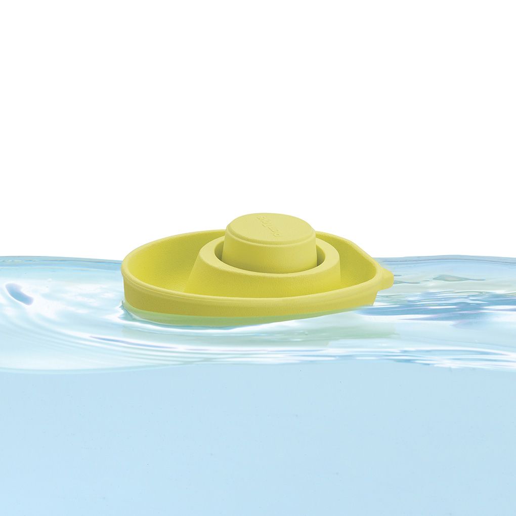 Yellow rubber duck floating on water with a white background