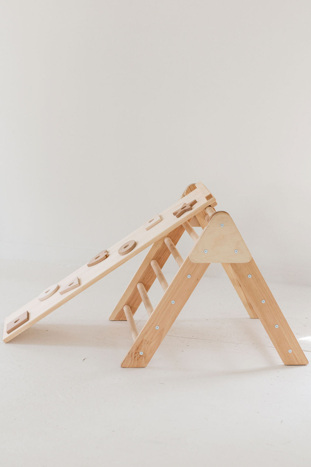Wooden climbing toy with multiple levels on a white background