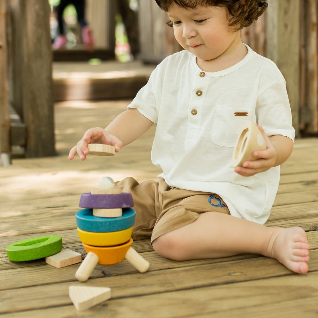 Child playing with wooden toys on a wooden deck