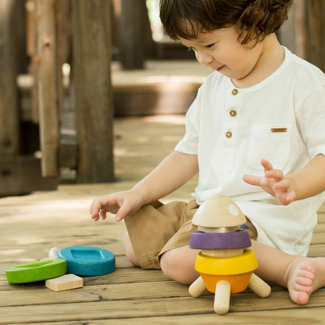 Child playing with colorful toys on a wooden deck