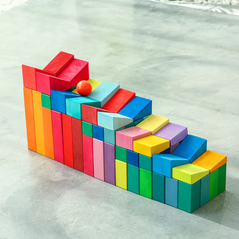 Colorful wooden blocks arranged in a geometric pattern on a reflective surface.