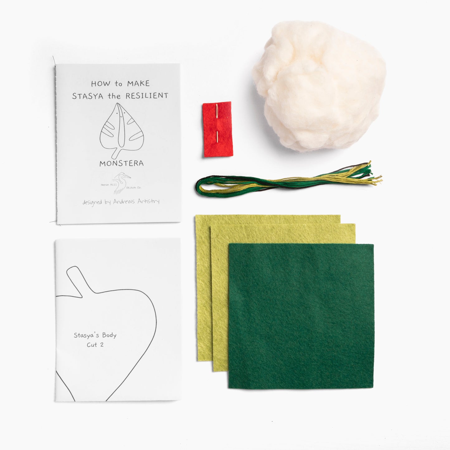 Crafting kit with felt sheets, a pattern, and other materials on a white background