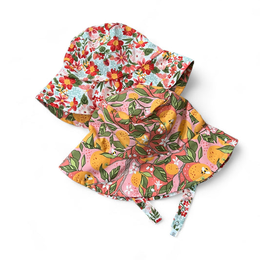 Two colorful headscarves with floral and fruit patterns on a white background