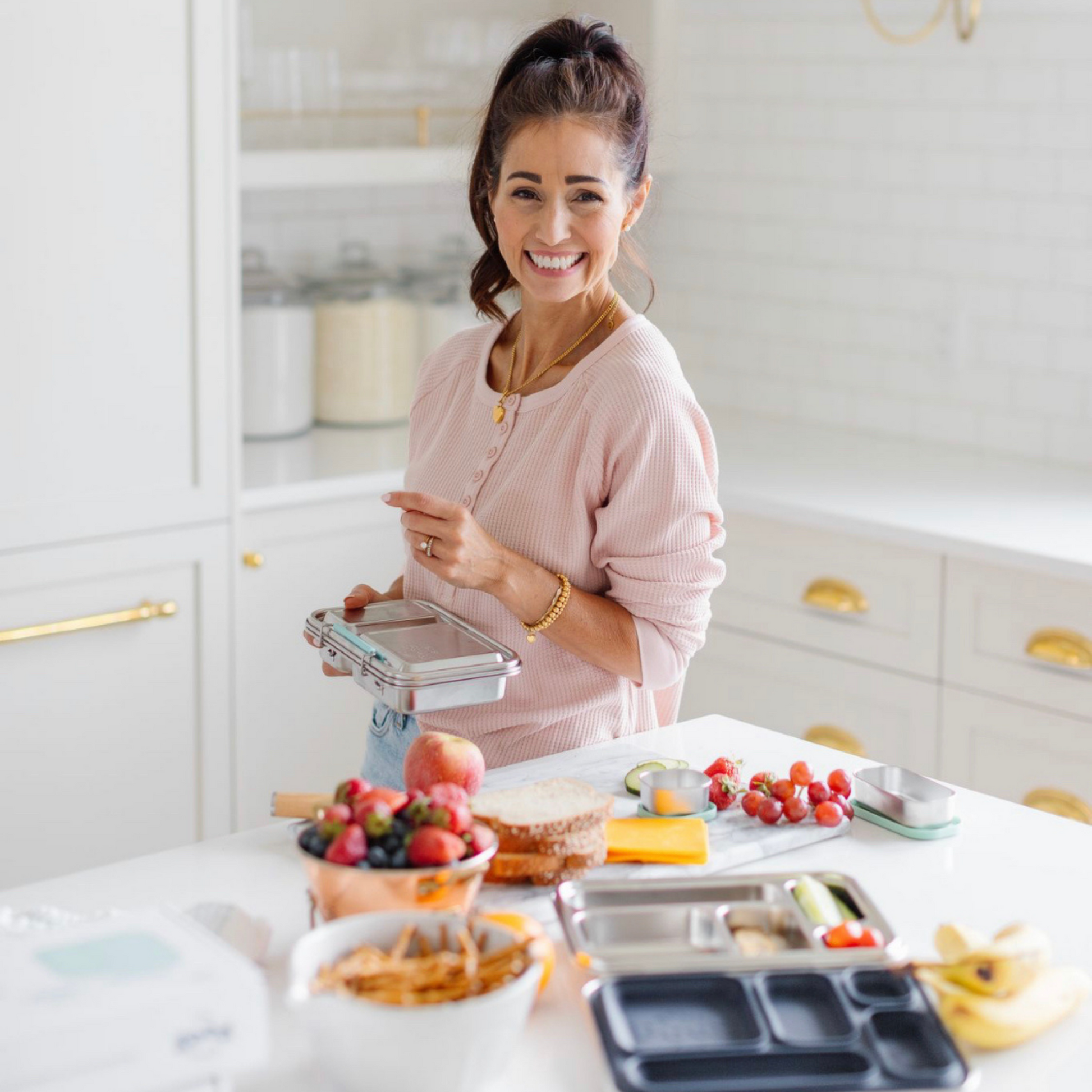Woman in a kitchen preparing food with various items on the counter.