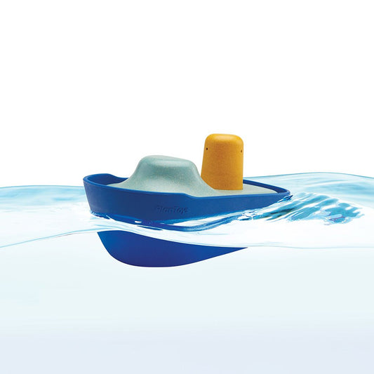 Toy boat with a yellow engine floating on water