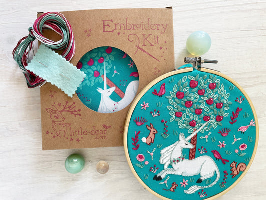 Embroidery kit with unicorn design on a wooden surface