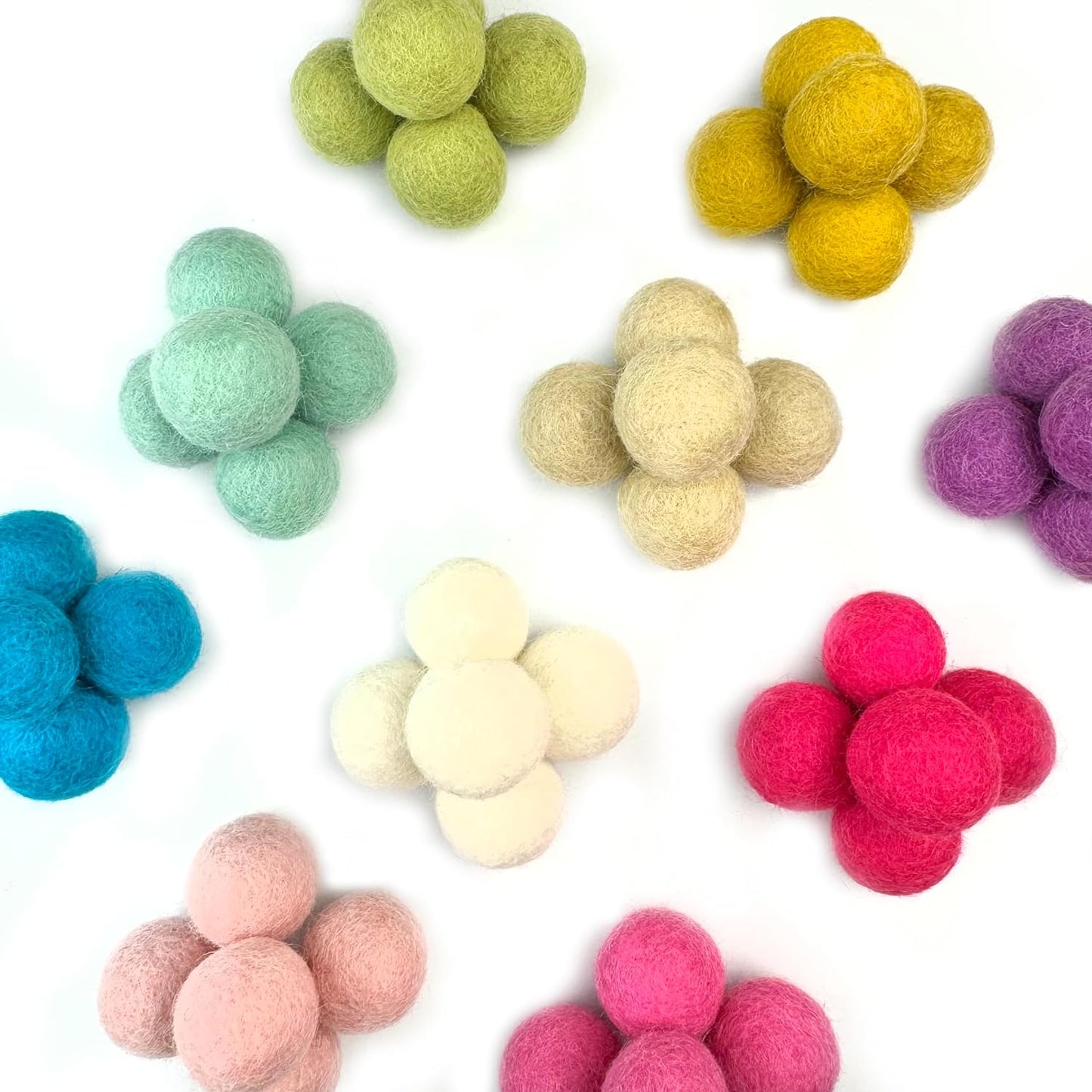 Colorful felt balls arranged in a pattern on a white background
