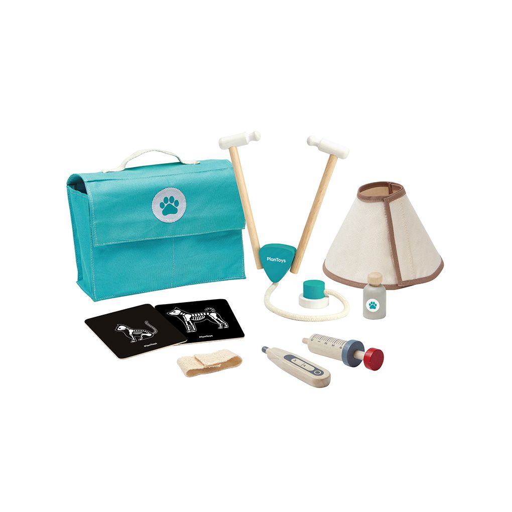 Collection of pet grooming tools including a turquoise bag with a paw print, lamp, and various handheld tools on a white background.