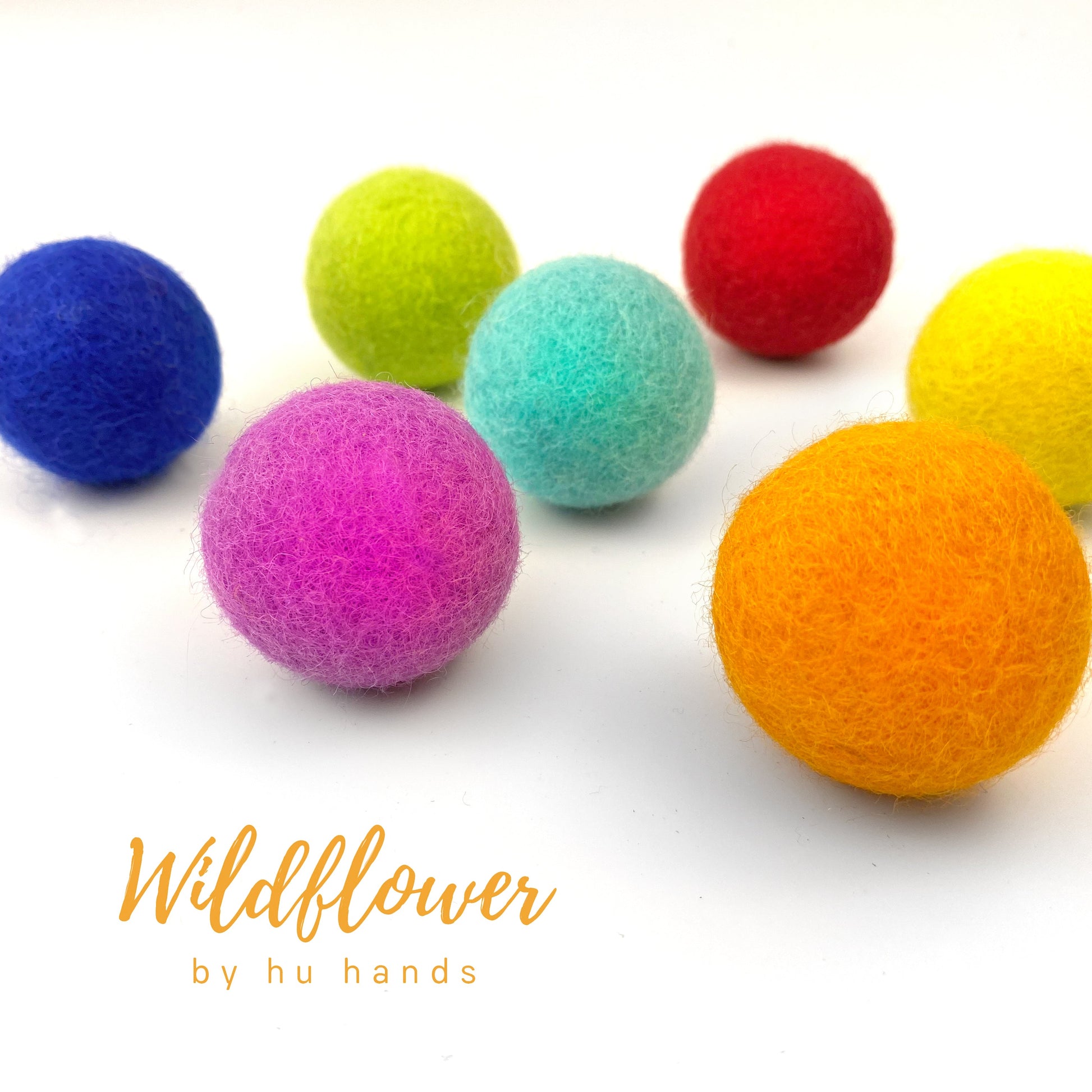 Colorful felt balls on a white background with 'Wildflower by hu hands' text.