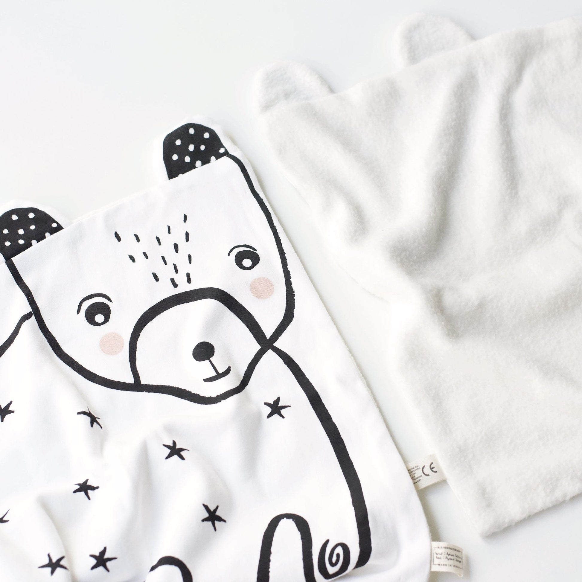 White baby blanket with black bear design on a white background