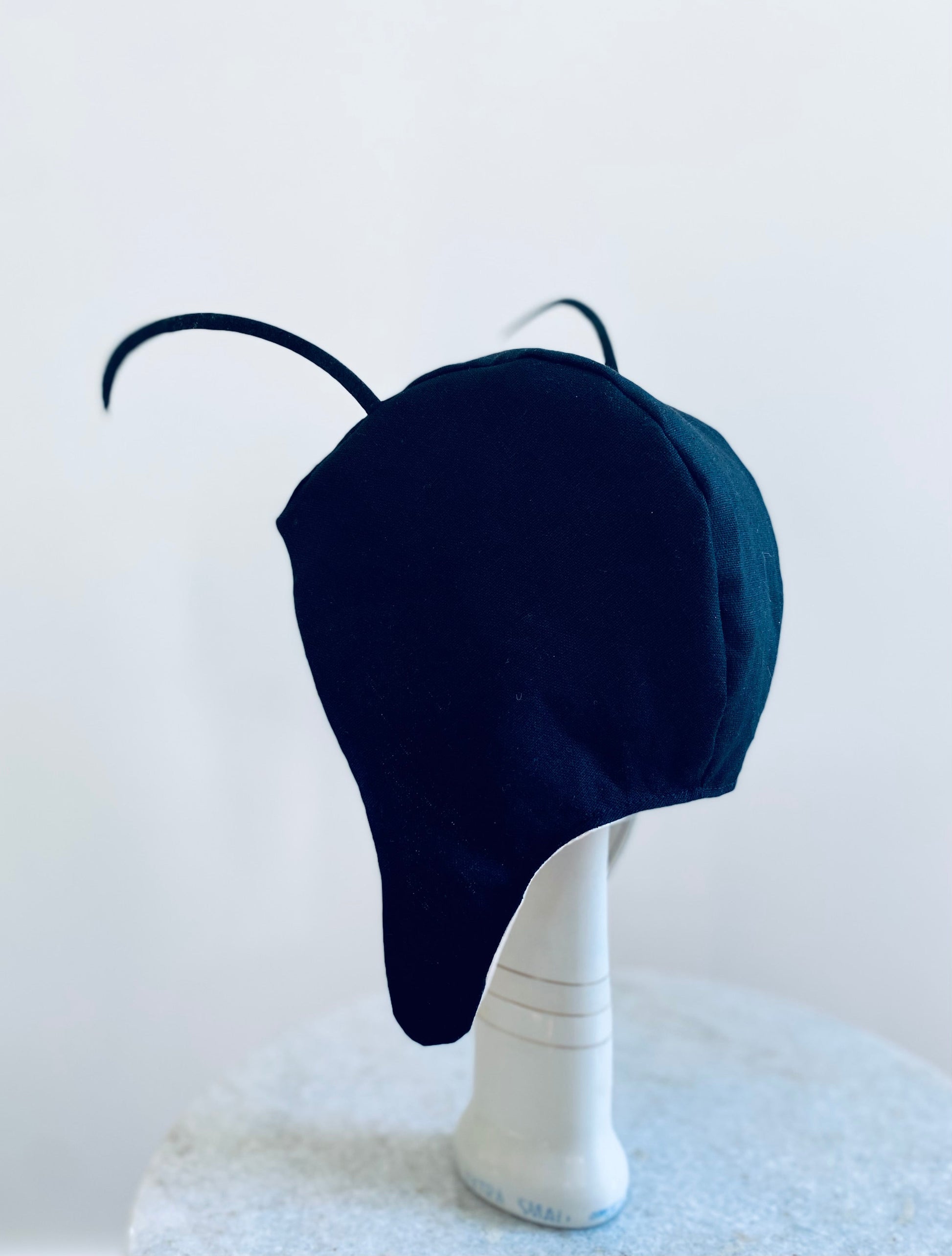 Navy blue hat on a mannequin head against a light background