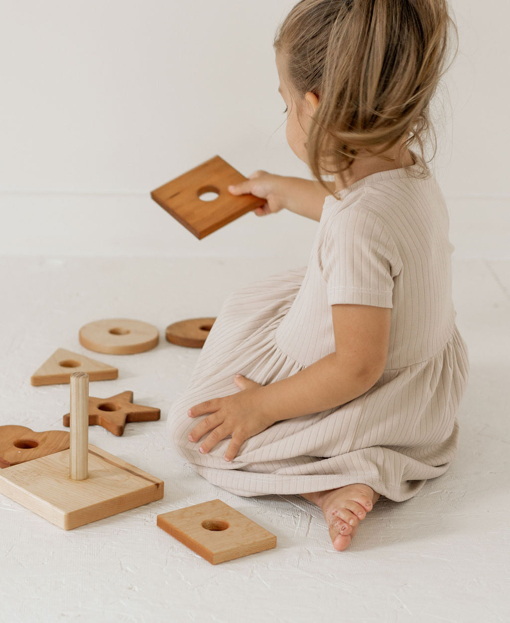 Child playing with wooden toys on a light surface