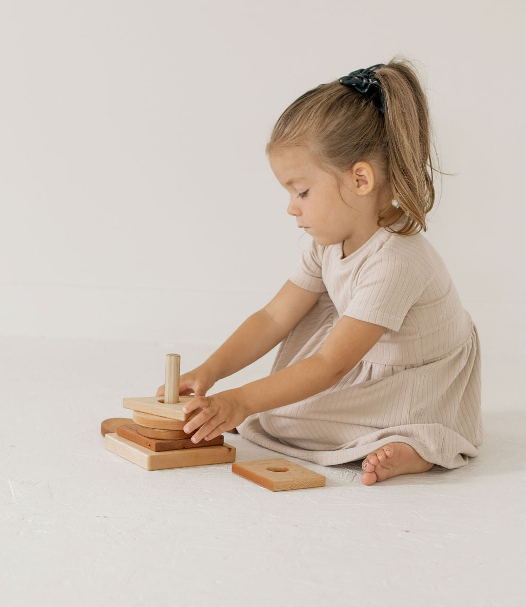 Child playing with wooden toys on a plain background