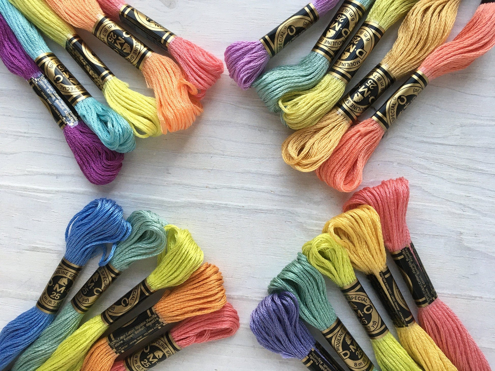 Colorful embroidery threads arranged in a fan shape on a light wooden surface.